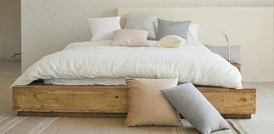 En la superficie de madera dura hay una almohada blanca y una